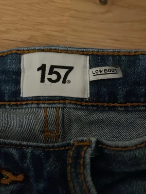 Blå bootcut jeans från 157 - Säljer ett par blå jeans från 157 med bootcut-modell och låg midja. Jeansen kan vara lite stora i midjan men ett bälte hjälper absoulut! De har varit använda 2 gånger och säljer de även för att de var lite stora i midjan!💓