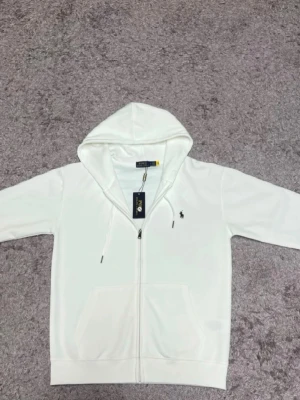 Vit Ralph lauren zip  - Säljer en vit Ralph lauren zip i storlek M. Den har inga defekter eller skador från cnfans notera därför att de är stockbilder. Dm för frågor diskuterar gärna pris 
