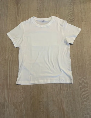 FutureWear T-shirt XS-L (Unisex) - Stilren FutureWear t-shirt med modern design som passar perfekt till vardag och streetstyle. Enkel att matcha och funkar året runt. Passformen är tajt, så rekommenderas att ta en storlek större för en skönare fit. Unisex – passar alla. Finns i storlekar XS–L. 🌍✌️