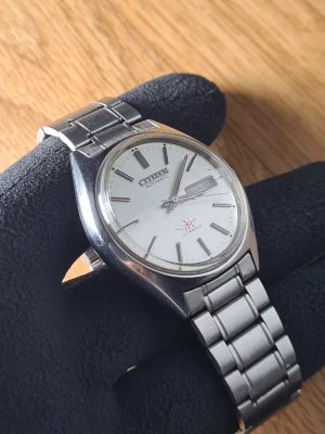 Citizen Eagle 7 Automatic - Vintage Citizen Eagle 7 (~1970)  21-jewel automatic (self-winding)  Sällsynt vit/silver urtavla Hesalitglas  Mycket bra skick för dess ålder. Urtavlan är lite dammig vid närmare granskning.   Finns mindre tecken på ålder. Dock helt funktionell och håller tiden väl.   +/- 30s per dygn  Diameter: ~34mm  Armband passar upp till ~18cm