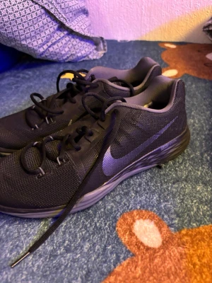 Svarta Nike Dual Fusion sneakers - Säljer ett par svarta Nike Dual Fusion sneakers med mesh-ovandel och klassisk swoosh på sidan. Skorna har snörning, platt sula och en riktigt skön dämpning. Perfekta för dig som vill ha stilrena och bekväma skor till vardagen eller träningen.