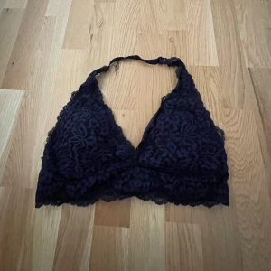Spetsig bralette topp - En bralette topp med blommig spets och triangelformade kupor från Hunkemöller. Svårt att visa på bild, men den är en väldigt djup mörkblå färg
