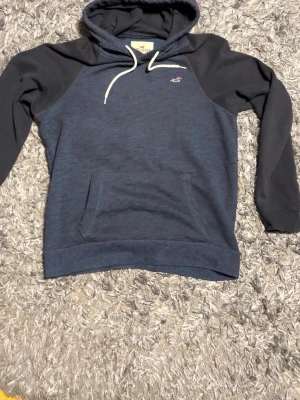 Marinblå Hollister hoodie – storlek L - Marinblå hoodie från Hollister. Mjuk och skön med klassisk passform. Storlek L. Bra skick, inga kända defekter.