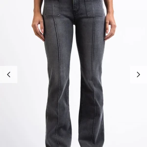 Svarta bootcut jeans med fickor - Snygga svarta jeans med bootcut passform och markerade sömmar längs benen. Framtill finns två stora fickor och baktill klassiska jeansfickor. Jeansen har hög midja och är tillverkade i ett mjukt denim-material som ger en cool och avslappnad vibe.