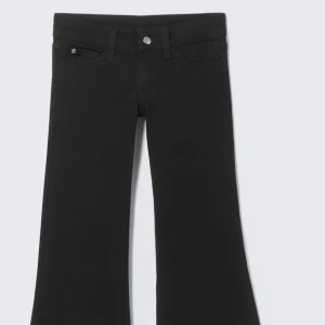 Svarta flare jeans low waist - Svarta jeans med flare-ben och lowwaist, byxorna är från weekday och har ett litet hål i låret ingenting som syns när man har på sig dom, endast andvänd en gång. kan gå ner o pris eller byta mot samma storlek i modellen booty bei 