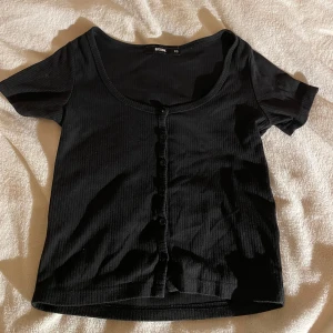 Svart topp med knappar - En svart topp med knappar på storlek Xs🙏