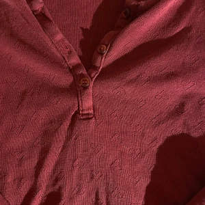 Vinröd långärmad tröja  - Vinröd långärmad tröja från Polarn O. Pyret med små invävda hjärtan över hela tyget. Storlek 134/140 men passar som magtröja för mig som är xs/s🙏