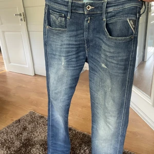 Replay Anbass slim fit jeans blå - Säljer ett par Replay Anbass slim fit jeans i klassisk blå tvätt med slitningar och en snygg fade. Storlek 32/30 men funkar till 32/32 också väldigt bra. Har bara använt dom några gånger så de är Mycket bra skick på dom. Väldigt sköna jeans med bra med stretch. Nypris på dom ca 2000kr köpta på boozt. Hör av dig om du har några funderingar:) 