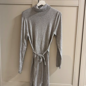 Grå stickad klänning med polokrage - Cubus S - Mysig grå stickad klänning från C med polokrage och knytskärp i midjan. Långärmad och i mjukt material som ger en chill och stilren vibe. Perfekt för lager-på-lager och enkel att styla med boots eller sneakers. * Fint skick - endast prövad  * Skickar samma dag eller dagen efter  *  Rökfritt hem * Passa på att kolla mina andra annonser, du får mängdrabatt och jag tackar ja till rimliga bud  * 🤍