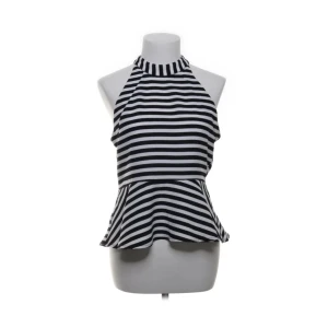 Randig halterneck topp från Ava - Snygg svartvit randig halterneck topp från Ava med peplumvolang nertill. Toppen har hög hals och är ärmlös, perfekt för dig som gillar en trendig och lekfull stil. Tillverkad i ett mjukt och lätt material som känns skönt mot huden.