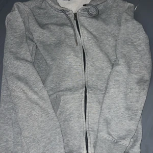 EA7 Emporio Armani Grå hoodie - Snygg grå hoodie från Emporio Armani med dragkedja och huva. Nya priset är 2500kr men jag släpper den för 1100kr. Pris går att diskutera vid bra snabbaffär😁😁