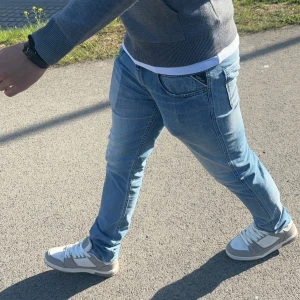 Replay Anbass ljusblå jeans - Säljer ett par Replay Anbass jeans i ljusblå. Jeansen har en slim passform, normal midja och raka ben. Materialet är stretchigt jeans för extra komfort. Perfekt för dig som gillar stilrena och moderna jeans. Personen på bilden är 180