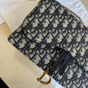 Dior saddle pouch with chain medium - Säljer min Dior Saddle Pouch i storlek medium. Väskan är i mycket fint skick, knappt använd och väl omhändertagen.  Dustbag och kvitto medföljer.