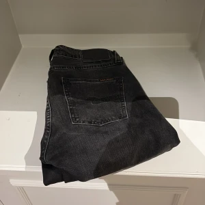 Svarta Nudie jeans - Säljer ett par svarta skinny jeans från Nudie Jeans i storlek 28/32. Perfekta för dig som gillar en smal passform och stilren look.