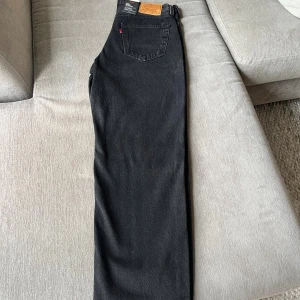 Levi's 568 Loose Straight svarta jeans - Svarta jeans från Levi's modell 568 Loose Straight. De har en rak och loose passform med klassisk femficksdesign och Levi's läderpatch bak. Jeansen är tillverkade i 100% bomull och har en mörk ton som ger en cool vibe.