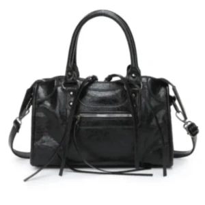 Svart handväska i skinn med dragkedja - Cool svart handväska i glansigt skinn med både handtag och axelrem. Väskan har flera långa dekorativa remmar framtill, silverfärgade detaljer och en praktisk dragkedja på framsidan. Mått: 30x20x10 cm. Perfekt för dig som gillar edgy och stilren design.