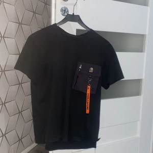 Äkta parajumpers tröja! - Svart t-shirt från Parajumpers med unik ficka på bröstet, dragkedja och orange Parajumpers-nyckelband. Varan är äkta+ pris kan diskuteras