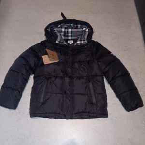 Burberry puffer jacka, size M - Den är jätte skön att ha på sig, luvan är nödigt när det är kallt väder så denna jackan tycker jag är perfekt, funkar som en vest också, kan diskutera priset och så kan jag mäta längd och bredden åt dig. 