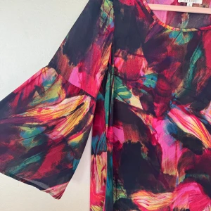 Färgstark mönstrad blus från Spense - Säljer en supercool blus från Spense i storlek S med färgstarkt abstrakt mönster i rött, rosa, gult, grönt och blått. Blusen har vida, trekvartsärmar och är tillverkad i ett lätt, skirt material som ger en festlig känsla. 