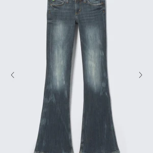 Blå bootcut jeans från Cheap Monday - Säljer ett par blå bootcut jeans från Cheap Monday med snyggt slitna detaljer och klassisk femficksdesign. Jeansen har en cool tvätt och är tillverkade i en mix av bomull, polyester och elastan för skön stretch. Perfekta för dig som gillar en avslappnad men trendig look.