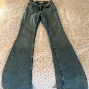Blå bootcut jeans från Perfect Jeans - Snygga ljusblå bootcut jeans från Perfect Jeans med klassisk femficksdesign och dragkedja. Jeansen har en utsvängd passform nertill och är tillverkade i mjukt denimtyg som ger en avslappnad vibe.