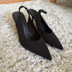 Svarta klackar  - Snygga svarta klackskor från Stradivarius med spetsig tå och öppen häl. Skorna har en smal klack och är tillverkade i ett slätt syntetmaterial. Jag köpte dessa i somras men aldrig haft användning för det vilket betyder att de är i nytt skick💗