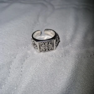 Chrome Hearts silverring med kors - Cool och chunky silverring från Chrome Hearts i 925 sterling silver. Ringen har ett öppet band och är dekorerad med detaljerade korsmönster runt om. Perfekt statement-piece för dig som gillar edgy och unik stil.