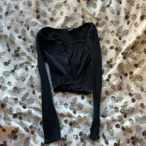Svart ribbad croppad kofta - Svart långärmad croppad kofta från Gina tricot. Storlek M men sitter som XS. 