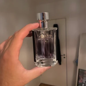 Stilren Prada parfymflaska - Snygg parfym från Prada i elegant flaska. Perfekt för dig som vill ha en exklusiv touch i din samling. Passar dig som gillar stilrena accessoarer och vill sticka ut med något från ett välkänt modehus.