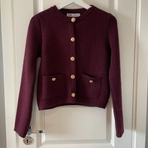 Vinröd Zara kofta - Säljer denna vinröda kofta med guldknappar från Zara!❤️💛 Väldigt fint skick, använd ca 3 ggr då den är för liten. Perfekt till hösten då den är varm och bekväm!❤️‍🔥