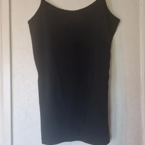 Svart linne med smala, reglerbara axelband - Ett stilrent svart linne från Vila med smala justerbara axelband och rak passform. Linnet har en enkel, minimalistisk design som gör den lätt att matcha med olika accessoarer. Perfekt för dig som gillar en clean look. Knappt använt då det hamnat underst i högen av linnen 🫣