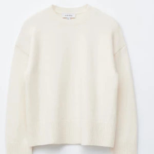 Krämvit stickad tröja & Other Stories - Supermjuk och krämvit stickad tröja från & Other Stories. Tröjan har rund hals, ribbade muddar och en relaxed fit som ger en chill vibe. Perfekt att slänga på sig när det är kyligt ute. (Lånad bild) 