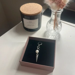 Silvrigt örhänge med pärldetalj - Snyggt örhänge i silverfärg med en rund vit pärla och en spetsig hängande detalj. Modern design med ringar och coolt häng. Perfekt för dig som gillar statement-smycken och vill sticka ut. Tvättas med våtservetter och handsprit innan frakt. 🩷