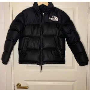 Svart pufferjacka från The North Face - Säljer en svart pufferjacka från The North Face! Jackan är köpt för ett tag sedan men fortfarande super skick!🫶 OBS medium youth (kids) 