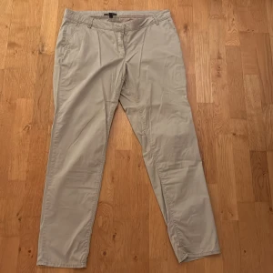 Beige chinos med raka ben - Snygga beige chinos med raka ben och klassisk passform. Byxorna har sidfickor fram och två bakfickor med knapp. Perfekta för en clean och stilren look. Tillverkade i mjukt bomullsmaterial som känns skönt mot huden.