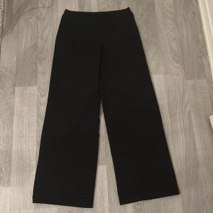 Svarta wide byxor från Kappahl - Svarta byxor från Kappahl i storlek 152. De har en hög midja och vida ben för en chill och trendig look. Tillverkade i mjukt material med 95% polyester och 5% elastan som ger lite stretch och skön passform. Jag har ej använt den mycket bara 1-3 dagar. Pris kan diskuteras.