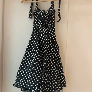 Svart prickig klänning FeverFish - Pga flytt och pga att denna klänning inte passar mig längre så säljer jag nu denna snygga klänningen. Har endast haft på mig den några enstaka gånger. Och så är det en liten fläck på den som inte ville bort oavsett hur mycket jag än har försökt, men annars är klänningen i bra skick.