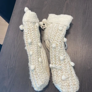 Stickade vita toffelstrumpor med bollar - Varma och sköna, från hunkemöller har storlek 39 och dem passar på mig gissar att de passar 36-40 typ