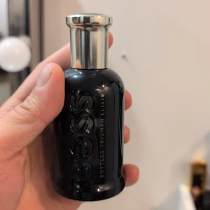 Boss Bottled Triumph Elixir 50ml - Boss Bottled Triumph Elixir i en snygg svart flaska. Parfymen är 50 ml och tillverkad i Spanien. Perfekt för dig som vill sticka ut med en modern och exklusiv doft. Tagit max 5 sprut