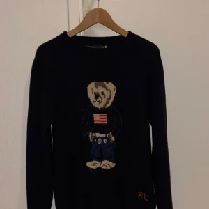 Polo Ralph Lauren Bear Sweater - Mörkblå Stickad Ralph Lauren tröja med den ikoniska björn designen. Använd endast ett par gånger, nyskick! Passar S-M