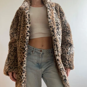 Leopardmönstrad pälsjacka i brun - Säljer en oversized pälsjacka med leopardmönster i bruna och svarta toner. Jackan är fluffig och har en bred krage, perfekt för att sticka ut. Den är långärmad och har en riktigt mysig känsla. Köpt på brandy melville