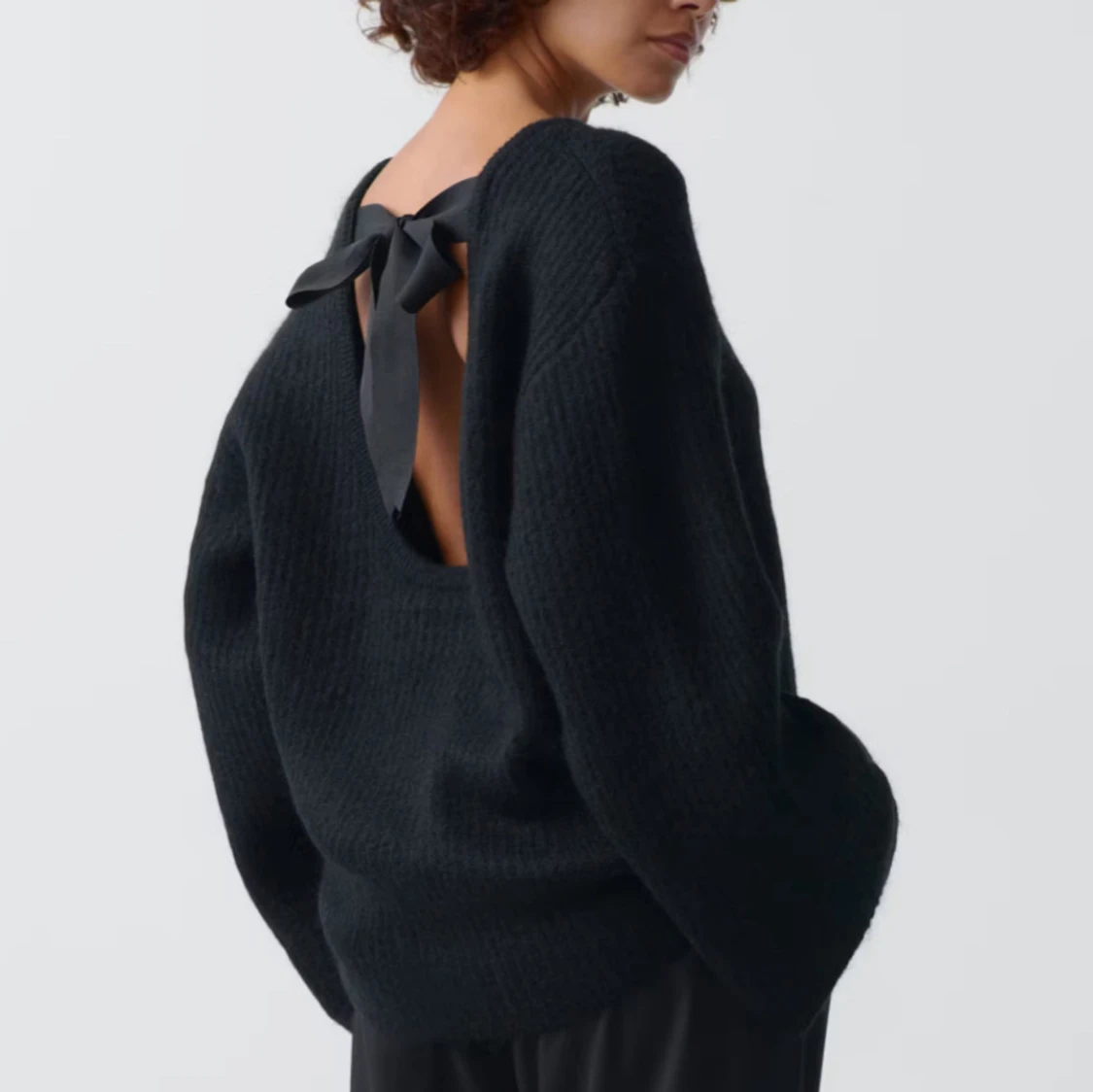 Svart stickad tröja med rosett i ryggen