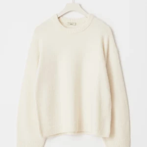 Vit stickad tröja från Gina tricot - Säljer en vit stickad tröja från Gina tricot med rund hals och breda ribbade muddar vid ärmslut och nederkant. Den är endast använd ett fåtal gånger!!