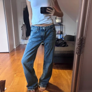 Full längd med låg midja - Säljer ett par blå zara jeans med låg midja och breda ben. Klassisk femficksmodell med knapp och dragkedja framtill. Säljer då dem tyvärr är för stora 