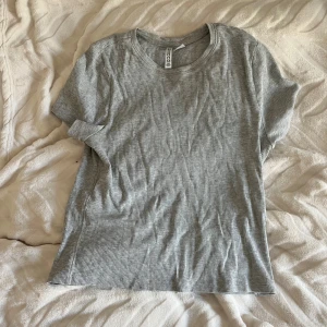 Grå ribbad t-shirt från H&M Divided - En basic grå ribbad t-shirt från H&M Divided i storlek M. 