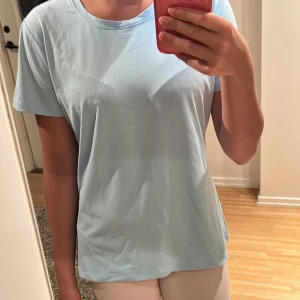 Ljusblå tränings T-shirt  - En stilren ljusblå tränings T-shirt med rund hals. Ganska lös passform så perfekt för dig som gillar lite mer avslappnad tränings look. Endast använd en gång.
