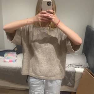 Beige stickad tröja med vida ärmar - Mysig beige stickad tröja med rund halsringning och vida, lite kortare ärmar. Tröjan har en loose passform och är perfekt för lager-på-lager. Enkel och stilren design som funkar till allt.