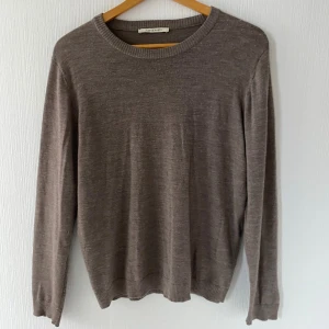 A Day’s March Alagón Merino Crew Taupe L - Snygg och stilren Alagón Merino Crew från A Day’s March i färgen Taupe Melange. Tillverkad i mjuk, högkvalitativ merinoull som både andas och håller värmen. Perfekt både för vardag och kontor, eller som bas i en capsule wardrobe. Passformen är normal/slim utan att vara tight. 100% merinoull Färg: Taupe Melange Alagón Merino Crew  Mått :  L Armlängd 54 cm Bröstvidd 110 cm Bottenvidd 90 cm Plagglängd 68 cm