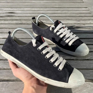 Prada skor - Snygga svarta sneakers från Prada i mocka. Skick; 8.5/10 riktigt bra med några små täcken på slitage som på snörena. Nypris ligger på 5000kr men säljs nu för 1499kr. Hör gärna av er vid funderingar.