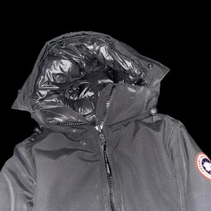 Svart dunjacka från Canada Goose - Säljer en svart dunjacka från Canada Goose med huva och klassisk logga på ärmen. Jackan har dragkedja framtill, två fickor och quiltad insida. Perfekt för kalla vinterdagar och riktigt snygg streetstil.